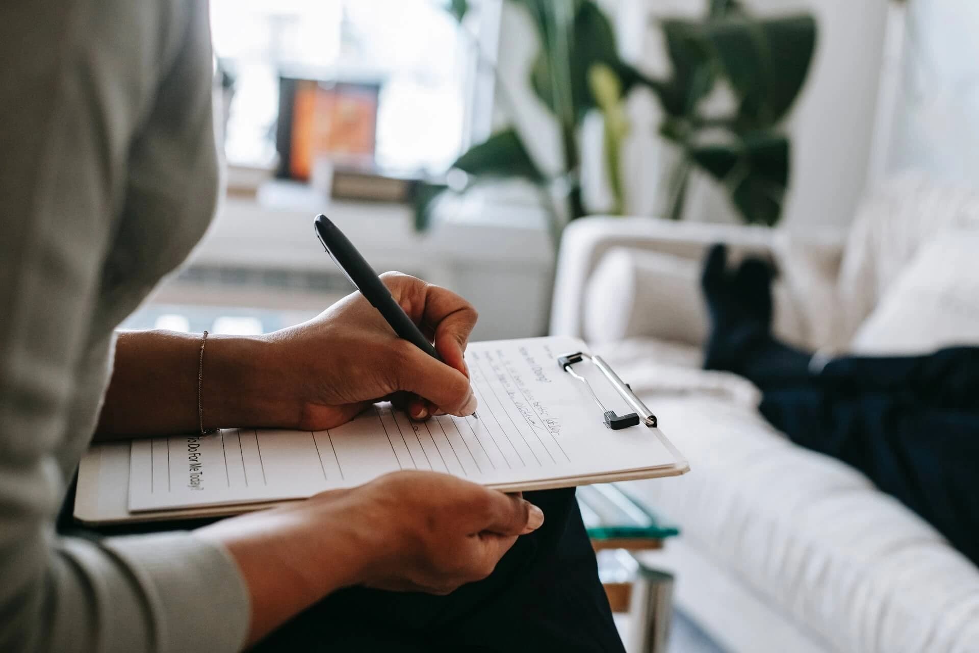 Woman taking notes on clipboard