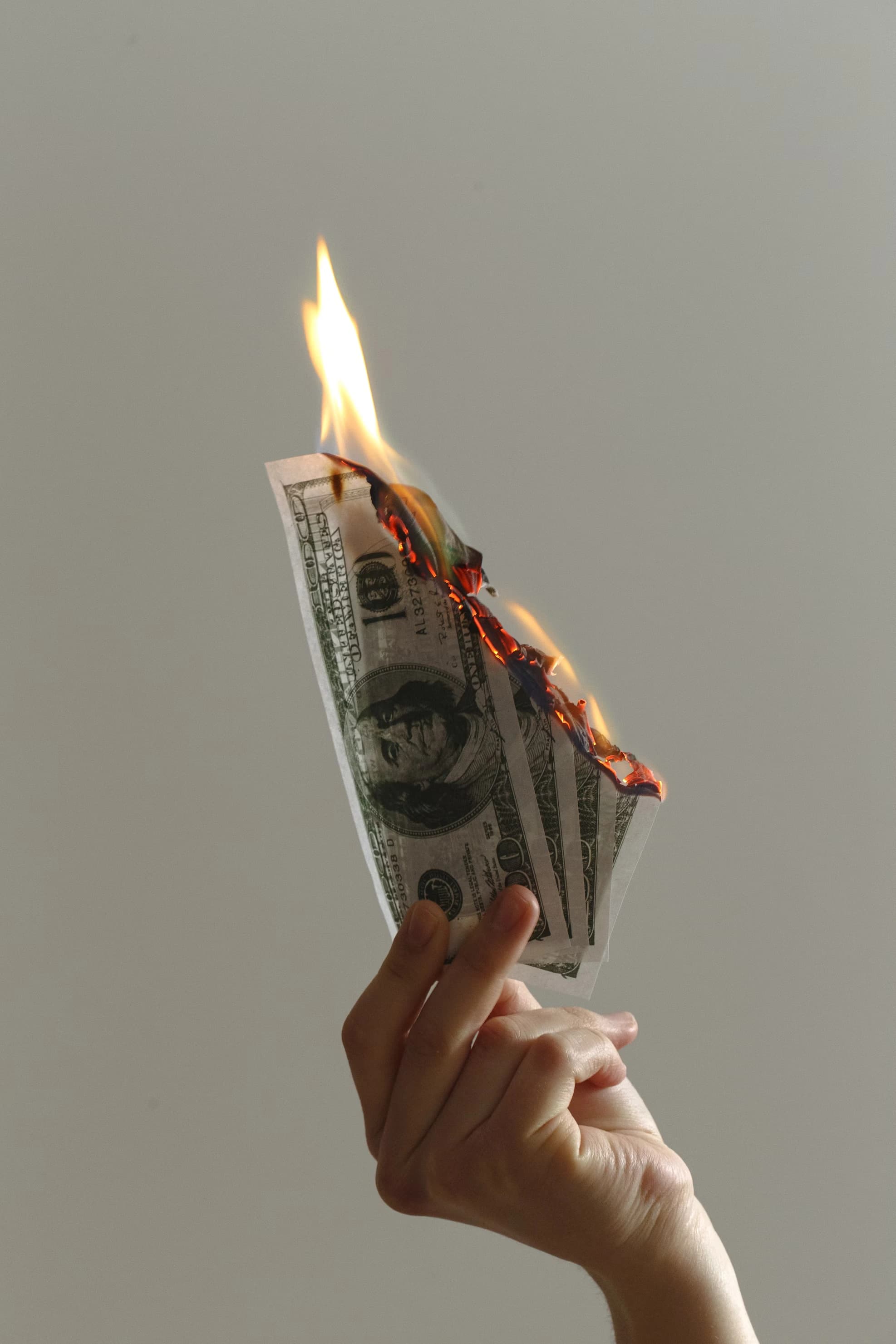 Man holding burning money