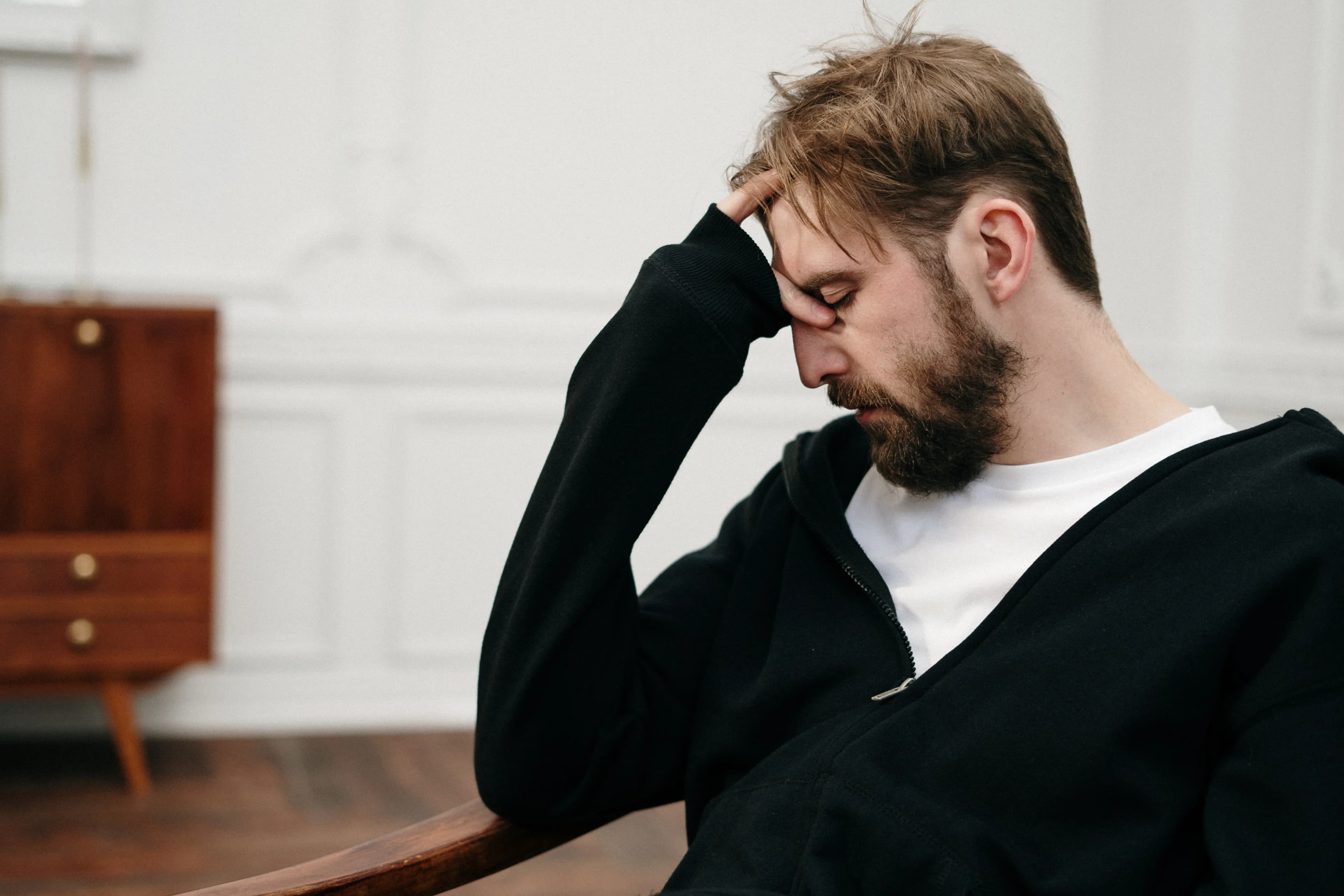 Man in chair holding his head